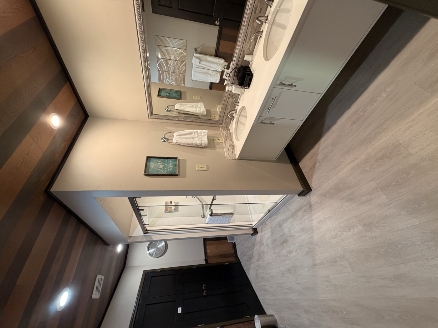 A bathroom with a double vanity and a large mirror
