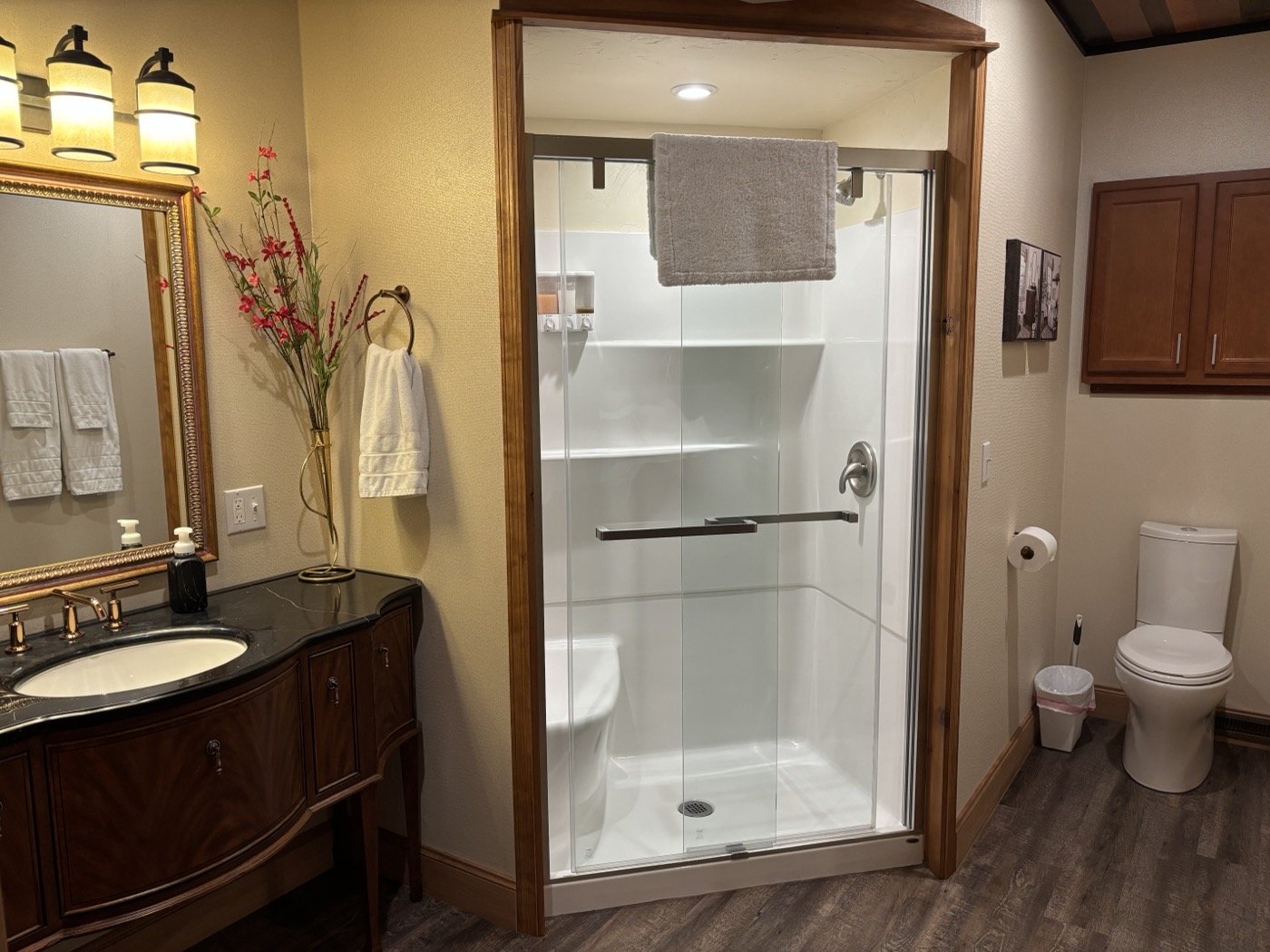 The second suite&rsquo;s bathroom — walk-in shower with a grab bar, vanity and mirror