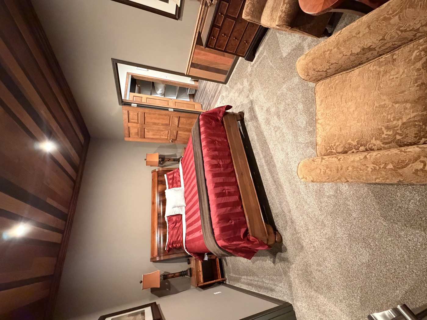 A bedroom with an upholstered bed under the plank ceiling