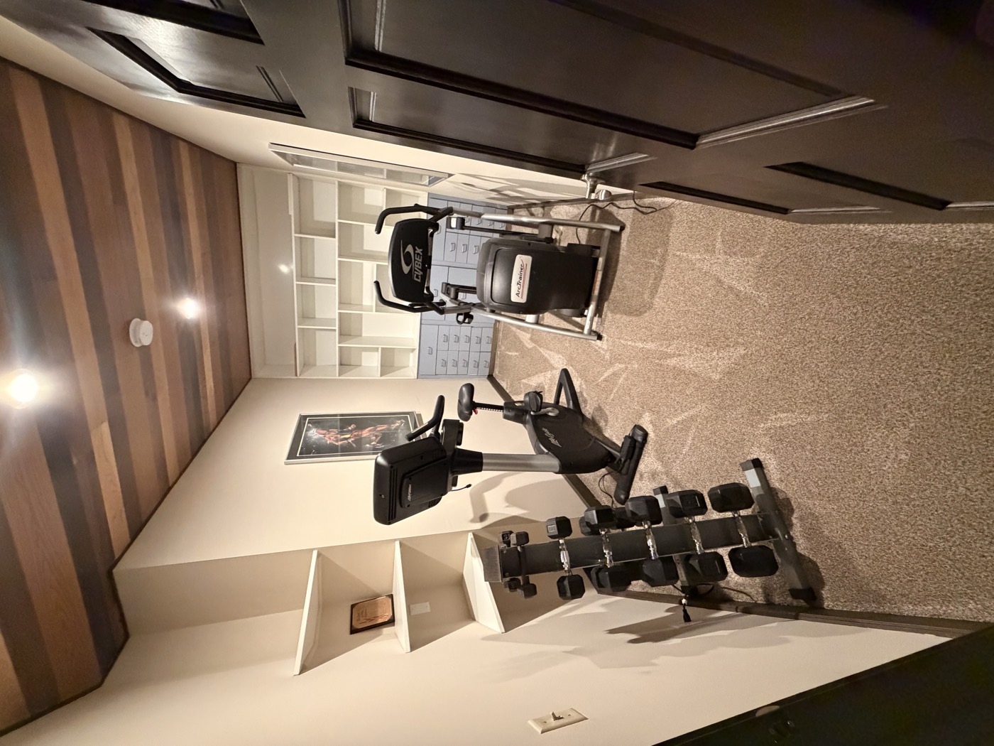 A room with an elliptical, stationary bike and free weights