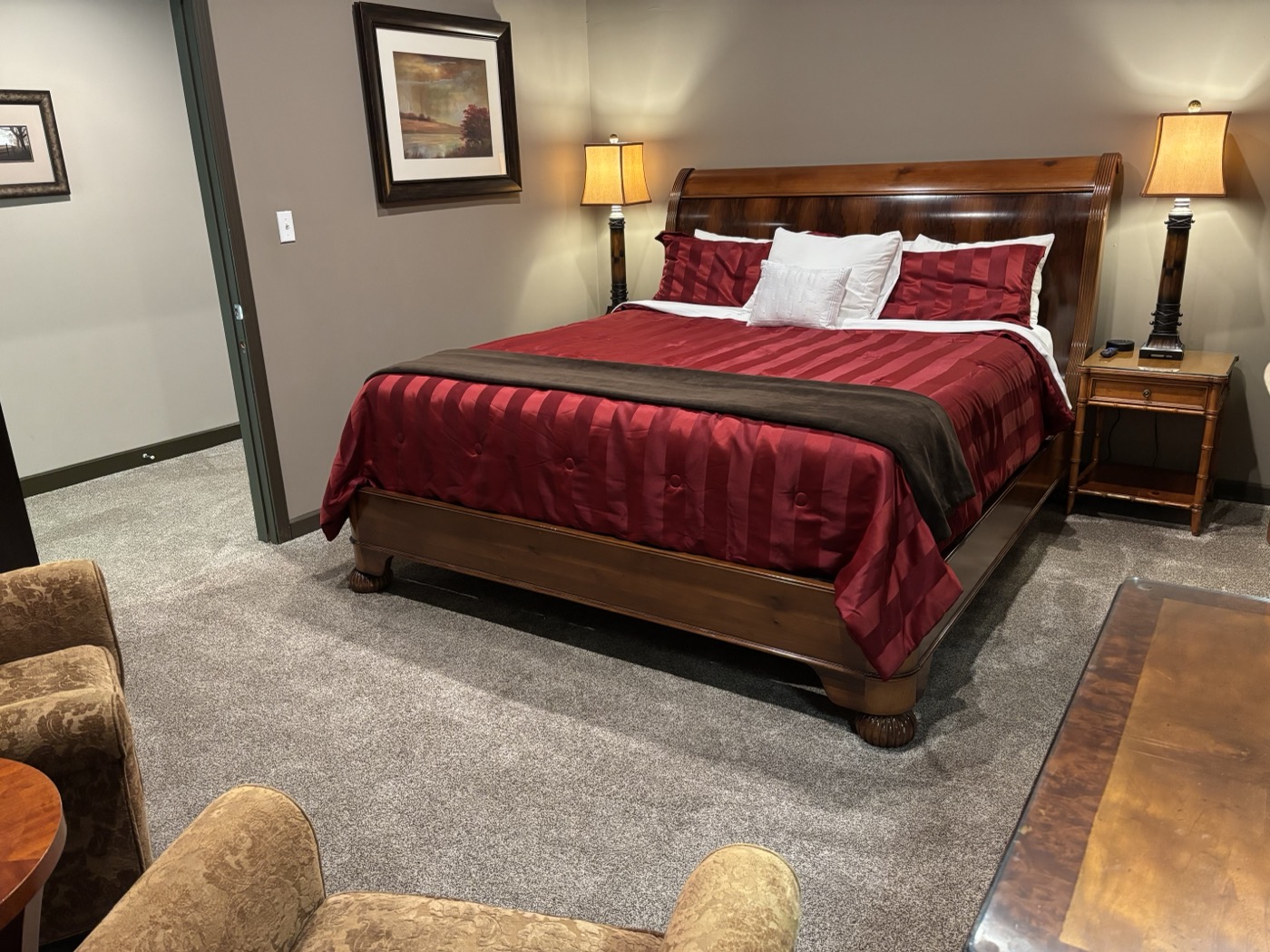 The second master suite &mdash; a king sleigh bed with a deep red comforter, reading lamps and armchairs